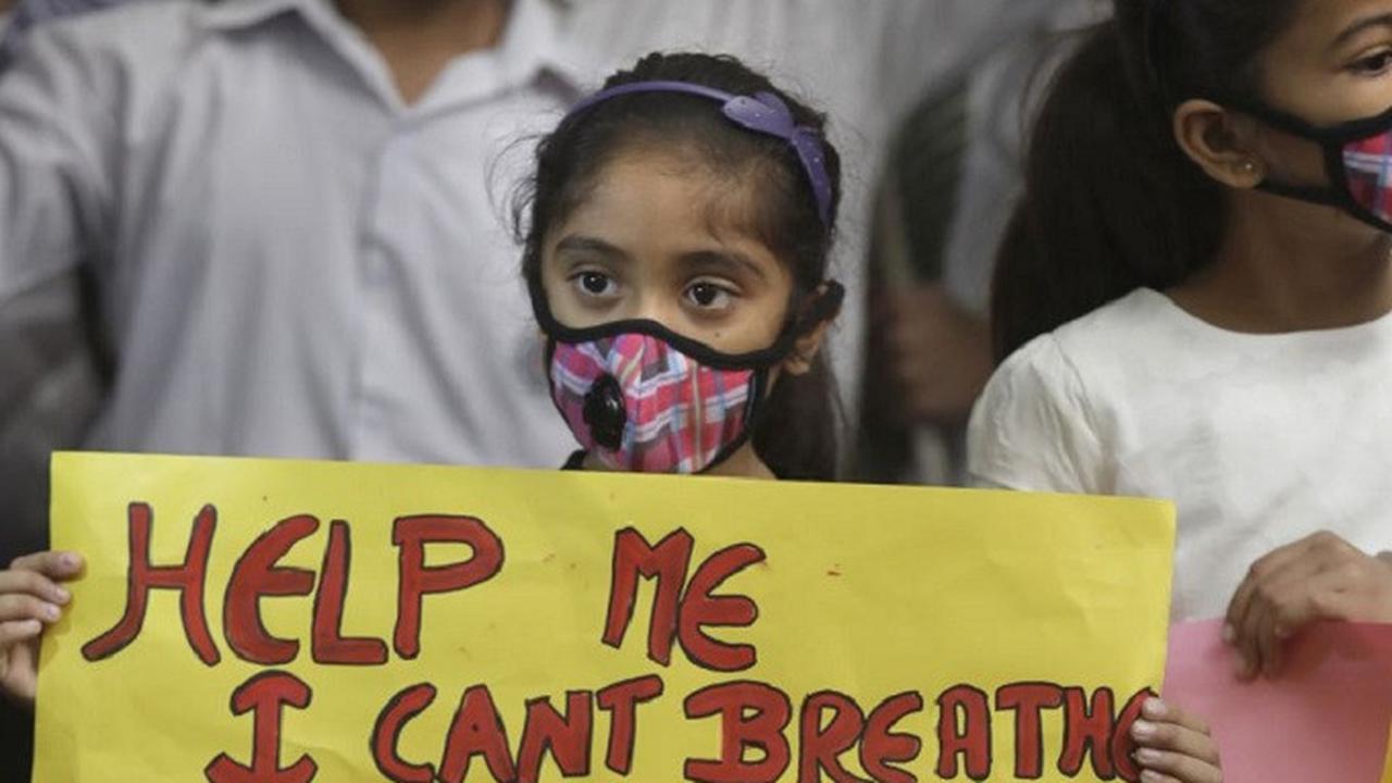 Seorang anak perempuan India memegang poster memprotes polusi udara di India, New Delhi, India, 6 November 2016 (AP)