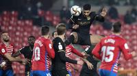 Bek Barcelona, Ronald Araujo (atas) menyundul bola dari ancaman pemain Granada dalam laga perempatfinal Copa del Rey 2020/21 di Nuevo Los Carmenes Stadium, Rabu (3/2/2021). Barcelona menang 5-3 (2-2) atas Granada melalui babak extra time. (AFP/Jorge Guerrero)
