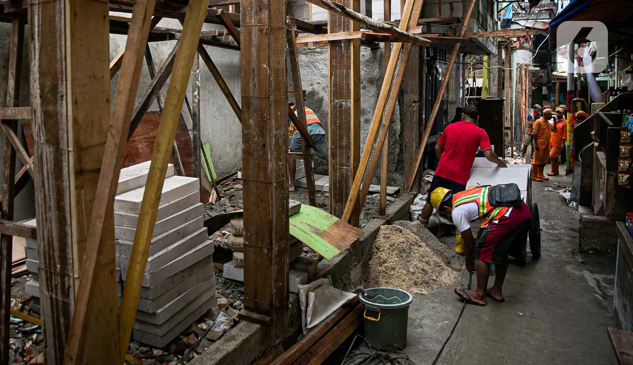 Para pekerja menyelesaikan pembangunan rumah panggung di dekat bantaran Kali Ciliwung, Kampung Melayu, Jakarta, Rabu (7/4/2021). Pemerintah Provinsi DKI Jakarta melakukan renovasi terhadap 40 hunian warga Kampung Melayu menjadi rumah panggung. (Liputan6.com/Faizal Fanani)