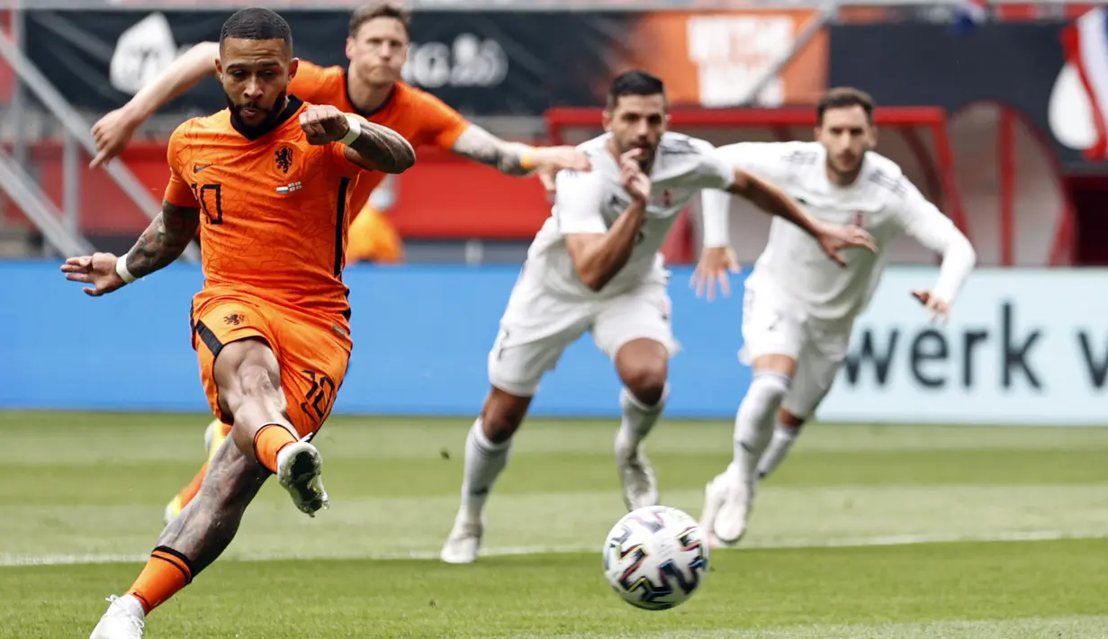 Pemain depan timnas Belanda, Memphis Depay melakukan tendangan dan mencetak gol dalam pertandingan uji coba jelang Piala Eropa 2020 melawan Georgia di De Grolsch Veste, Minggu (6/6/2021). Belanda menang meyakinkan 3-0. (MAURICE VAN STEEN / AFP)