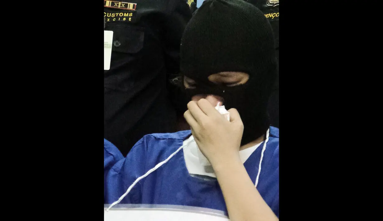 Salah satu tersangka penyelundupan narkotika jenis ekstasi di Kantor Pos Pusat, Jakarta, hanya tertunduk saat dimintai keterangan oleh petugas Bea Cukai dan BNN, (12/8/2014). (Liputan6.com/Faizal Fanani)