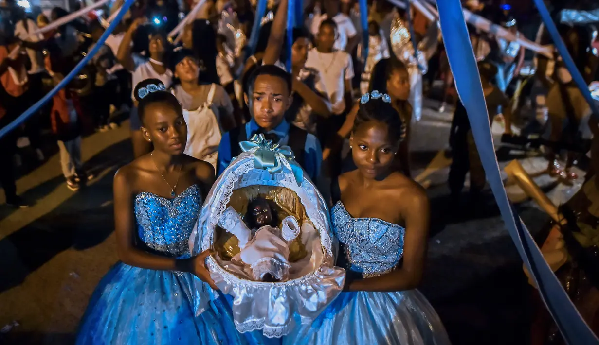 Afro-Kolombia memegang keranjang yang berisi "Nino Dios" (God Child) selama perayaan "Adoraciones al Nino Dios" di Quinamayo, Kolombia (18/2). Acara tersebut adalah perayaan Natal tradisional komunitas Afro-Kolombia. (AFP Photo/Luis Robayo)