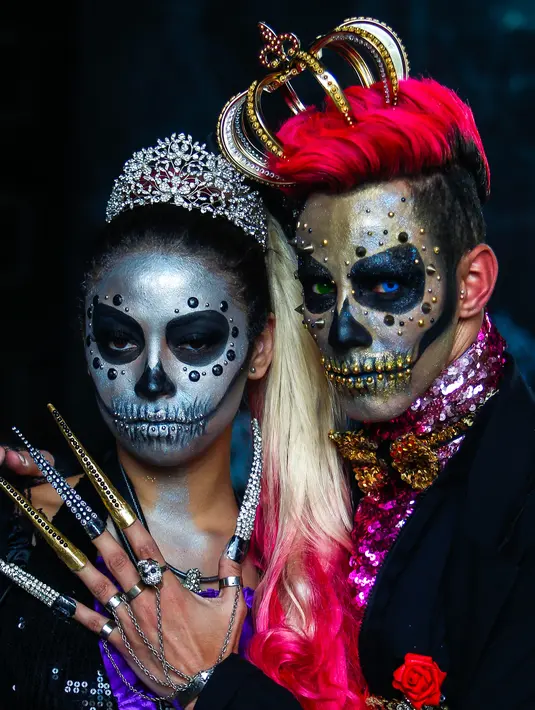 Sepasang pengunjung berpose dengan kostum dan dandanan menyerupai zombie dalam acara Zombie Walk di Sao Paulo, Brasil, Jumat (2/11). Ribuan orang beraksi sebagai Zombie memeriahkan peringatan Hari Para Arwah yang diadakan sejak 2006. (Mauro PIMENTEL/AFP)
