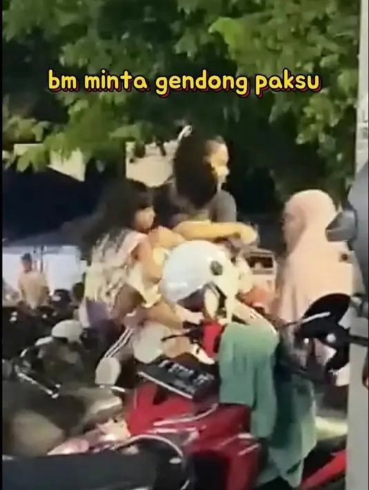 Azizah juga tampak santai manja dengan sang suami meski di tempat umum pinggir jalan. Saat Arhan gendong anak perempuan, Azizah tak mau kalah dan minta gendong juga. [Youtube@MomenBucin]