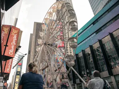 Biangalala raksasa yang baru dibuka berputar di Times Square, Manhattan, New York City, Rabu (25/8/2021). Bianglala setinggi 110 kaki atau setara dengan 11 lantai dari atas tanah tersebut beroperasi dari 25 Agustus hingga 12 September. (Scott Heins/Getty Images/AFP)