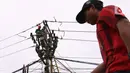 Petugas melakukan maintenence trapo listrik di Kota Tangerang, Banten, Jumat (26/11/2021). Pemerintah mau mendorong investasi baru terutama industri supaya konsumsi listrik bisa mengimbangi. (Liputan6. com/Angga Yuniar)