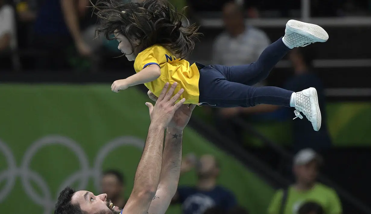 Kegembiraan membuat pevoli Brasil, William, langsung menggendong dan meluapkan kesenangannya bersama sang putri. (AFP/Juan Mabromata)
