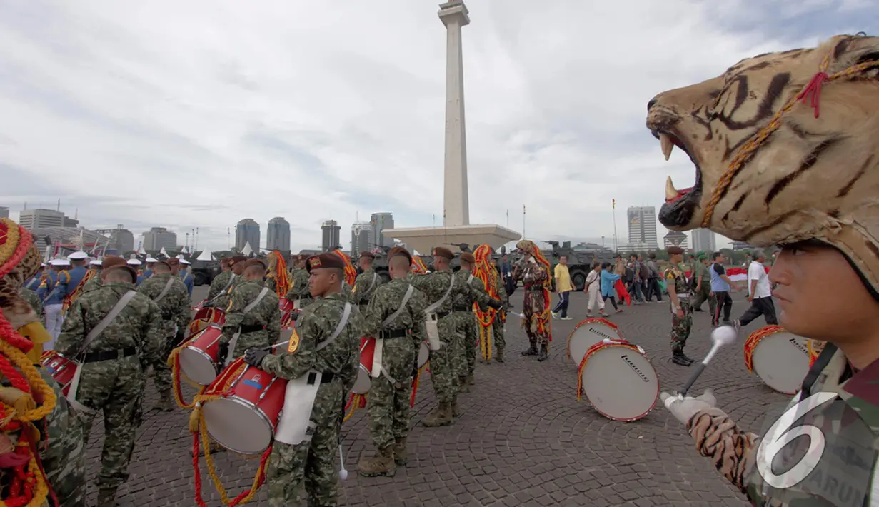 Puluhan anggota marching band TNI AD bersiap-siap memeriahkan pameran Alutsista di kawasan Monas, Jakarta, Jumat (12/12/2014). (Liputan6.com/Faizal Fanani)