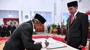Artidjo Alkostar (kiri) menandatangani nota pelantikan sebagai Dewan Pengawas KPK disaksikan Presiden Joko Widodo di Istana Negara, Jakarta, Jumat (20/12/2019). Upacara pelantikan Dewan Pengawas KPK dipimpin langsung Presiden Joko Widodo. (Foto: Biro Pers Setpres)