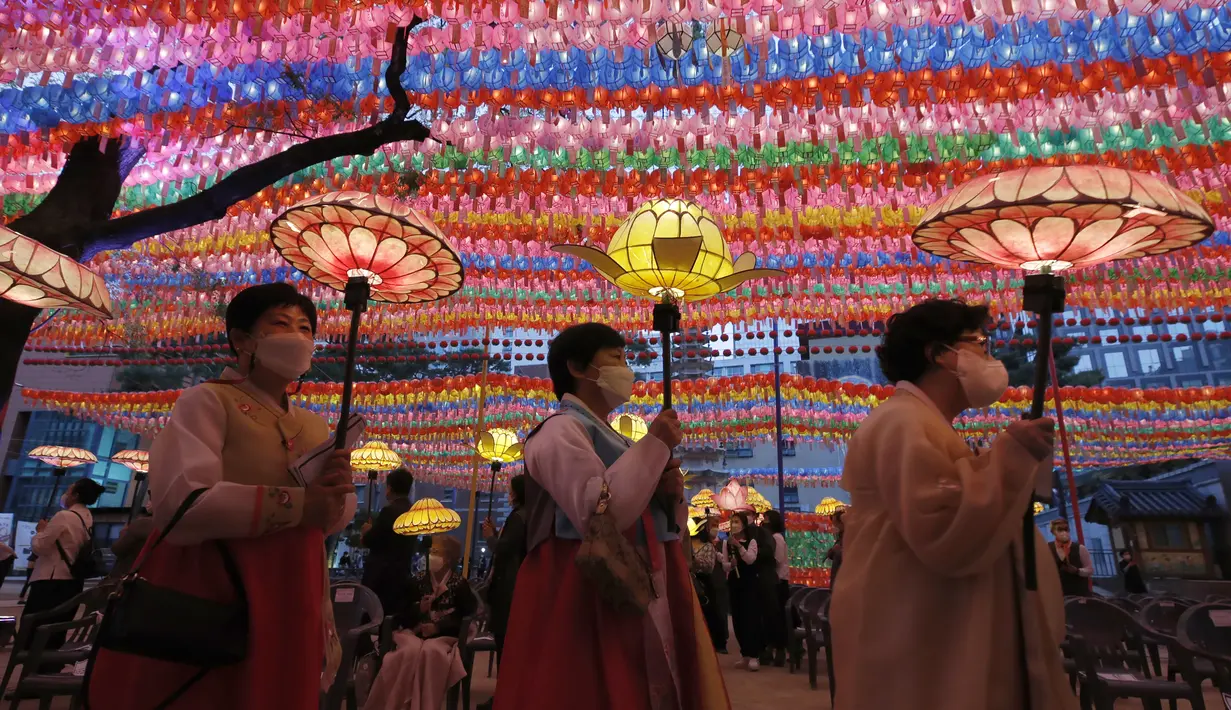 Umat Buddha mengenakan masker membawa lampion untuk merayakan ulang tahun Buddha yang akan datang pada 19 Mei di kuil Jogye, Seoul, Korea Selatan (6/5/2021). Di negeri Ginseng ini, ulang tahun Buddha dirayakan dengan menggelar ‘Lotus Lantern Festival’. (AP Photo/Lee Jin-man)