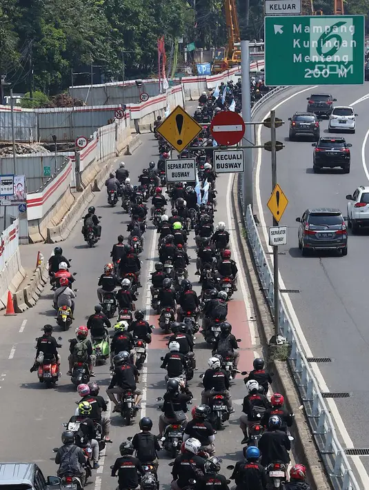 Konvoi buruh menggunakan sepeda motor melintas di Jalan Gatot Soebroto, Jakarta, Selasa (1/5). Ribuan buruh dari berbagai elemen memperingati perayaan Hari Buruh untuk menyampaikan aspirasi di sejumlah titik di Ibukota. (Liputan6.com/Immanuel Antonius)
