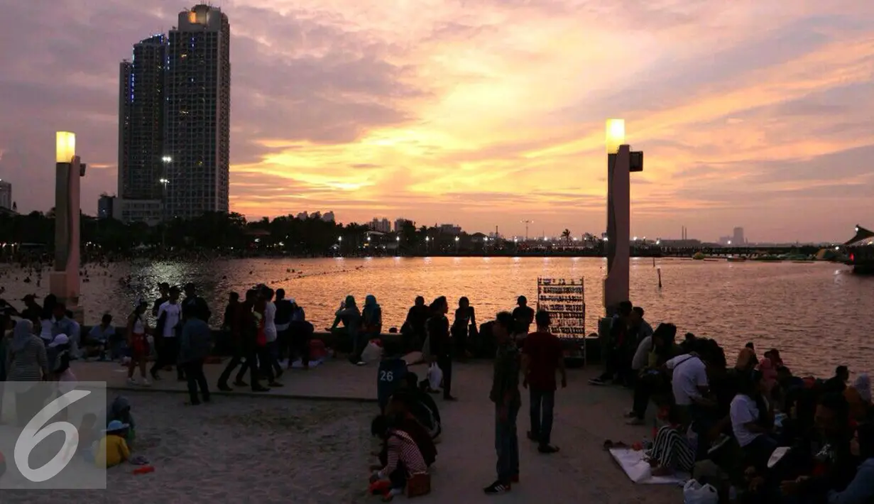 Warga Jakarta menikmati matahari terbenam di akhir 2016 di Ancol, Jakarta, Sabtu (31/12). Sebagian masyarakat merayakan pergantian tahun baru di pesisir Jakarta untuk menikmati matahari terbenam. (Liputan6.com/Angga Yuniar)
