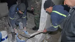 Para pekerja membersihkan puing ledakan bom bunuh diri di dalam kantor polisi di kawasan Midan, Damaskus, Suriah, 16 Desember 2016. Diketahui gadis cilik pelaku bom tersebut tewas dan seorang polisi terluka. (SANA/Handout via Reuters)