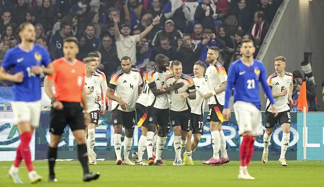 Toni Kroos bersama para pemain Jerman merayakan gol ke gawang Prancis pada laga persahabatan di Stadion Groupama, Minggu (24/3/2024). Pemain Real Madrid ini kembali hadir dengan sebuah assist dalam kemenangan atas Prancis. (AP Photo/Laurent Cipriani)