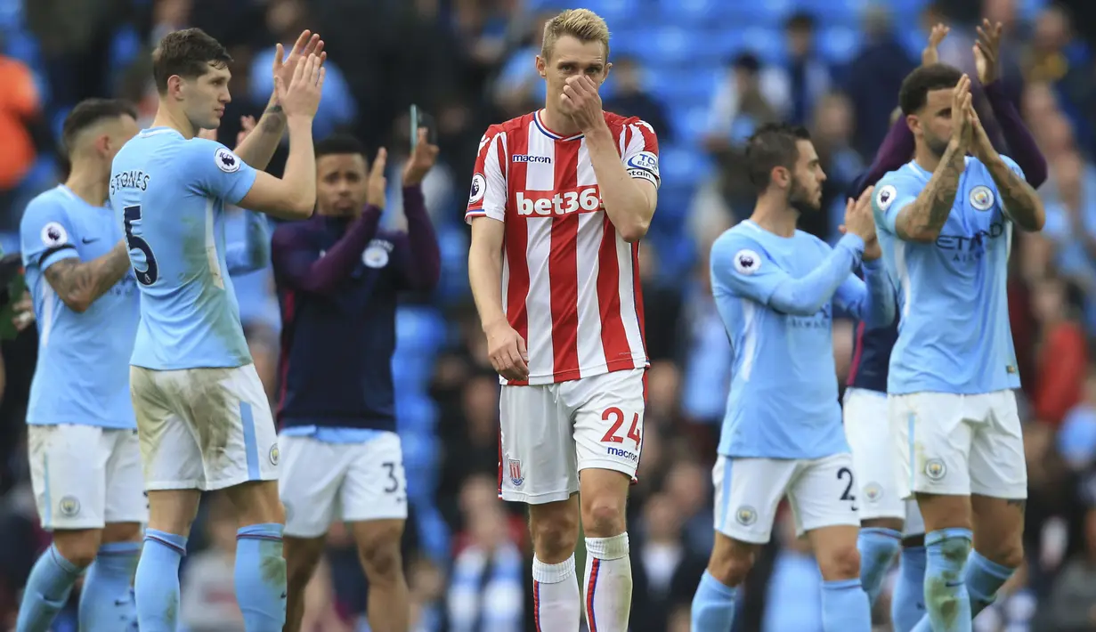 Pemain Stoke City, Darren Fletcher berjalan melewati para pemain Manchester City yang sedang merayakan kemenangan pada lanjutan Premier League di Etihad Stadium, Manchester, (14/10/2017). City menang 7-2. AFP/Lindsey Parnaby)
