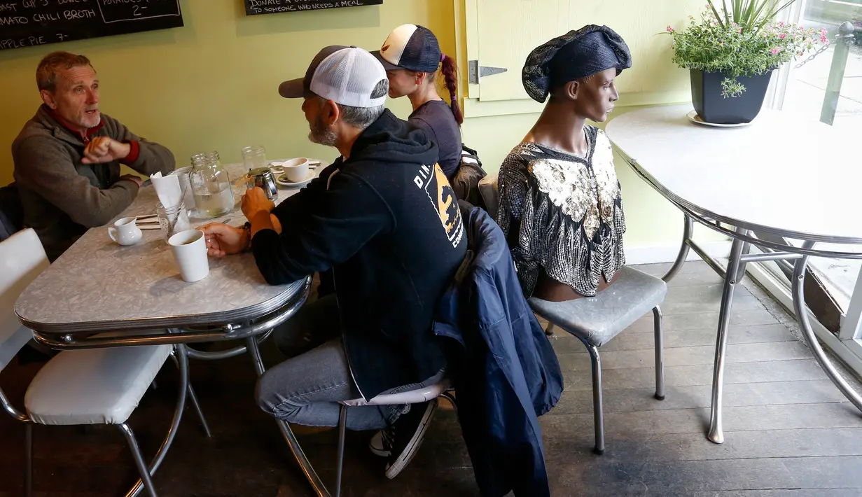 Manekin digunakan untuk menghalangi kursi di Roundel Cafe guna memberikan jarak fisik yang cukup bagi pelanggan di Vancouver, Kanada, pada 15 Juni 2020. Restoran Roundel Cafe menggunakan maneken alih-alih memberi pembatas pada kursi untuk membantu pelanggan menjaga jarak fisik. (Xinhua/Liang Sen)