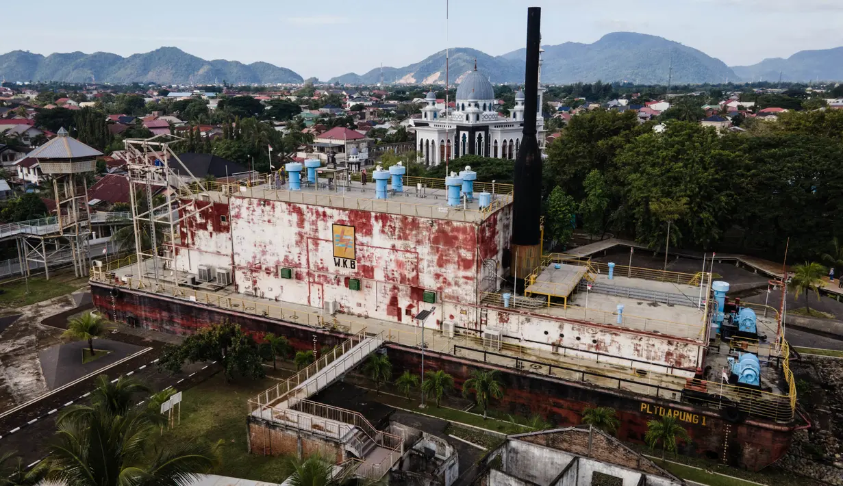 Foto udara menunjukkan PLTD Apung 1, kapal pembangkit listrik tenaga diesel seberat 2.600 ton yang terdampar di daerah pemukiman saat tsunami Samudra Hindia 2004, yang kini diubah menjadi taman museum bertema tsunami, di Banda Aceh, pada tanggal 25 Desember 2024. (Yasuyoshi CHIBA/AFP)