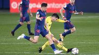 Pemain Atletico Madrid, Marcos Llorente, berebut bola dengan pemain Villareal, Manu Trigueros, pada laga Liga Spanyol di Stadion Ceramica, Minggu (28/2/2021). Atletico Madrid menang dengan skor 2-0. (AP/Jose Breton)
