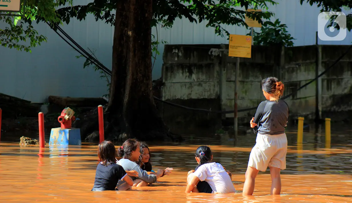 Sejumlah anak bermain air di Jalan Raya Kayu Putih, Jakarta, Minggu (23/2/2020). Usai hujan deras sejak Sabtu (22/2) malam hingga dini hari menyebabkan banjir di Jalan Raya Kayu Putih, Jakarta, Minggu (23/2). (merdeka.com/Magang/Muhammad Fayyadh)