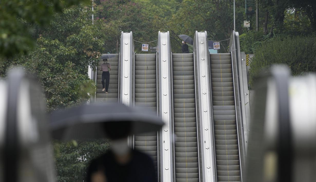 Orang-orang yang memakai masker untuk membantu mengekang penyebaran virus corona menggunakan eskalator di dekat stasiun kereta bawah tanah di Seoul, Korea Selatan, Selasa (31/8/2021). (AP Photo/Lee Jin-man)