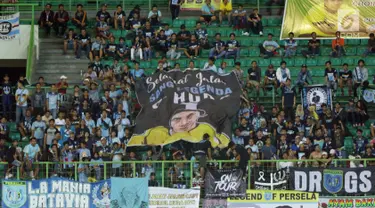 Suporter Laskar Joko Tingkir membentangkan bendera bergambar alm Choirul Huda saat menyaksikan laga Persela melawan Bhayangkara FC di Stadion Patriot Candrabhaga, Bekasi, Jumat (27/10). (Liputan6.com/Helmi Fithriansyah)