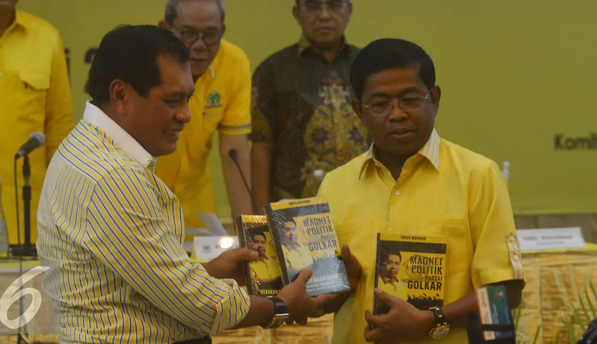 Sekjen Partai Golkar Idrus Marham  (kanan) memberikan buku kepada Nurdin Hallid saat acara sosialisasi panitia pengarah Musyawarah Nasional Luar Biasa Partai Golkar, Jakarta, Senin (2/5). (Liputan6.com/Johan Tallo)