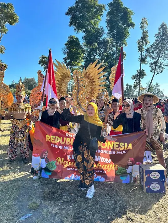 "KARNAVAL 1 ABAD @pemerintah.desaselo Kabupaten Boyolali Jawa Tengah . RT 001," tulis Novi membagikan beberapa potret bersama para tetangga dalam sebuah karnaval. [Instagram/novilisty_]