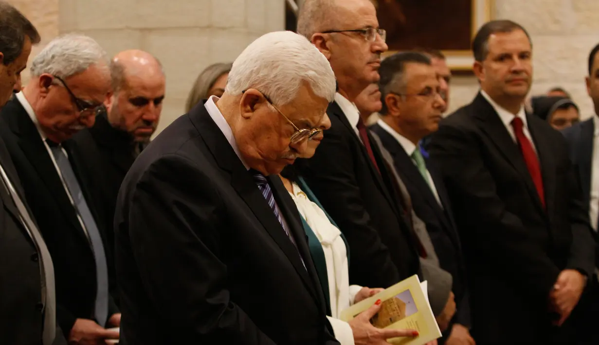Presiden Palestina Mahmoud Abbas saat menghadiri misa Natal di Gereja Santa Katarina yang terhubung ke Gereja Nativity, di kota Bethlehem di Tepi Barat, (25/12). (AFP Photo/Musa Shaer Poll)