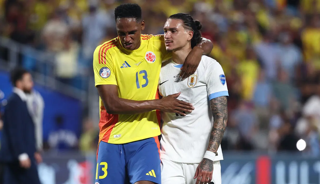 Bek Timnas Kolombia, Yerry Mina (kiri) berusaha menghibur striker Timnas Uruguay, Darwin Nunez usai berakhirnya laga semifinal Copa America 2024 di Bank of America Stadium, Charlotte, Amerika Serikat, Kamis (11/7/2024) pagi WIB. (AFP/Getty Images/Jared C. Tilton)