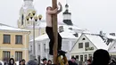 Seorang pria dibantu pria lainnya untuk memanjat sebuah tiang saat perayaan liburan Maslenitsa (Shrovetide) di Moskow, Rusia (18/2). Bedanya lomba ini diadakan dengan telanjang dada di tengahnya dinginnya salju. (AP Photo / Pavel Golovkin)