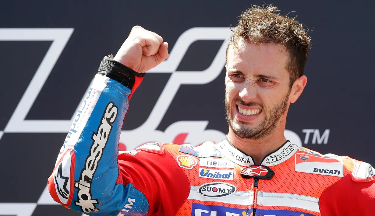 Pembalap Ducati, Andrea Dovizioso merayakan kemenangannya di podium setelah finis pertama pada MotoGP Catalunya di sirkuit Barcelona Catalunya, Minggu (11/6). Ini menjadi gelar juara yang kedua secara beruntun setelah Moto GP Italia. (AP/Manu Fernandez)