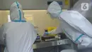Tim  medis  melakukan pemeriksaan hasil PCR COVID-19 di  Laboratorium Container (lab Con) COVID-19 RSKD Duren Sawit, Jakarta, Kamis (18/6/2020). (merdeka.com/Imam Buhori)