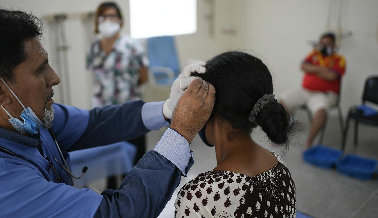 Seorang dokter melakukan terapi akupunktur pada pasien terpapar virus Corona COVID-19 yang baru pulih di pusat kesehatan yang dikelola pemerintah di lingkungan Coche di Caracas, Venezuela pada 25 Februari 2021. (AP Photo / Matias Delacroix)