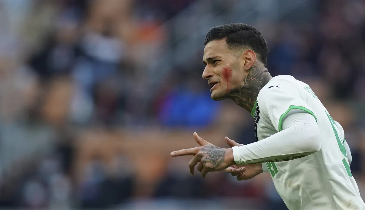 Penyerang Sassuolo, Gianluca Scamacca berselebrasi usai mencetak gol ke gawang AC Milan pada pertandingan lanjutan Liga Serie A Italia di stadion San Siro, Minggu (28/11/2021). Milan untuk sementara masih bercokol di urutan kedua dengan nilai 32. (Spada/LaPresse via AP)