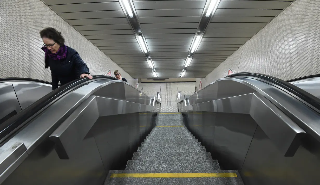 Penumpang menaiki eskalator pada pembukaan Stasiun Metro Maelbeek di Brussels, Ibu Kota Belgia, Senin (25/4). Stasiun tersebut akhirnya dibuka kembali setelah serangan bom 22 Maret 2016 yang menewaskan 35 orang dan melukai ratusan lainnya. (JOHN Thys/AFP)
