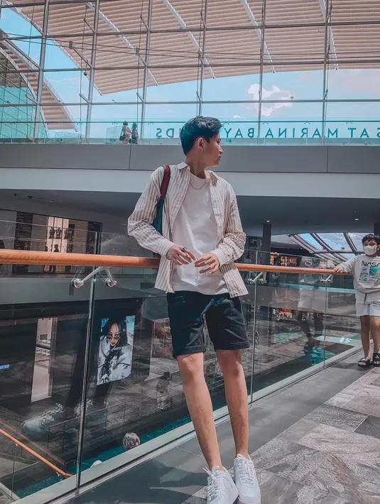 Rizwan Fadilah alias Njan adik Rizky Fabian ini suka gaya yang simpel, tapi stylish terlihat dari unggahannya di Instagram saat berpose mengenakan celana pendek dipadu dengan kaos dan kemeja di Marina Bay Sands. (Instagram/rizwanfadilah.a.s)