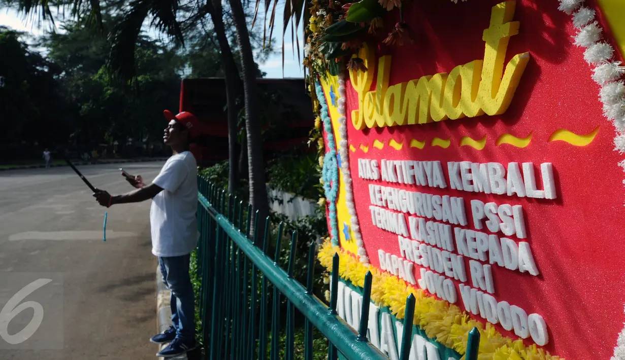 Warga berselfie foto di depan kantor PSSI di kawasan Stadion Gelora Bung Karno, Jakarta, Sabtu (27/2/2016). Seseorang mengatasnamakan pecinta sepak bola mengirimi ucapan selamat kepada PSSI. (Liputan6.com/Helmi Fithriansyah)