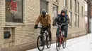 Dua pria bersepeda di Washington Street saat salju turun di Ann Arbor, Michigan, Rabu (2/2/2022). Badai musim dingin besar dengan jutaan orang Amerika di jalurnya membawa campuran hujan dan salju ke bagian tengah Amerika Serikat. (Jacob Hamilton/Ann Arbor News via AP)