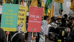 Massa yang tergabung dari Serikat Petani Indonesia (SPI) bersama mahasiswa menggelar aksi demo di depan gedung DPR/MPR RI, Jakarta, Selasa (24/9/2019). Dalam aksinya mereka menuntut DPR menghentikan pembahasan lima rancangan undang-undang yang menyangkut pertanian. (Liputan6.com/Faizal Fanani)