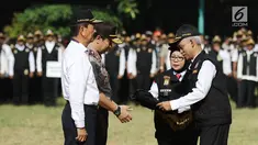 Ketua Pokdarkamtibmas Polda Metro Jaya Heru Riyadi memberikan rompi ke Wakapolda Metro Jaya, Brigjen Pol Purwadi saat apel besar di lapangan Sabhara Mapolda Metro Jaya, Jakarta, Sabtu (12/5). (Liputan6.com/Herman Zakharia)