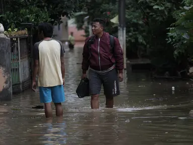 Warga beraktivitas saat banjir merendam kawasan Cipinang Melayu, Jakarta Timur, Senin (5/2). Akibat intensitas hujan yang cukup tinggi, permukiman di wilayah Cipinang Melayu tergenang air setinggi 30-40 cm. (Liputan6.com/Arya Manggala)