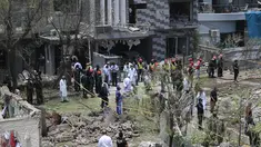 Petugas polisi, penyelidik, dan petugas penyelamat berkumpul di lokasi ledakan, di Lahore, Pakistan, Rabu (23/6/2021). Ledakan itu terjadi sekitar 120 meter dari kediaman Hafiz Saeed di Lahore, menurut laporan. (AFP/Arif Ali)