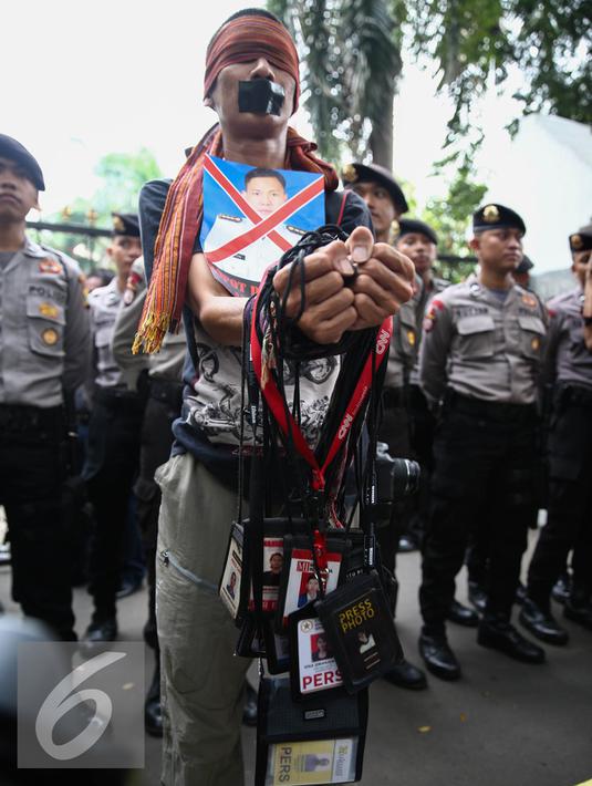 Seorang jurnalis mengikuti aksi solidaritas di depan Kantor Menkopolhukam, Jakarta, (25/8).  Dalam aksinya para Jurnalis juga menuntut agar peristiwa yang kerap berulang tersebut tidak terjadi lagi. (Liputan6.com/Faizal Fanani)