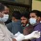 Paramedis dan warga menggunakan masker untuk mencegah penularan virus Nipah di RS Government Medical College Kozhikode, Kerala, India Selatan, Kamis (24/5). Nipah adalah infeksi yang dapat ditularkan ke manusia dari hewan. (AP Photo)