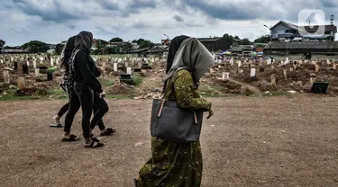 Warga berziarah ke makam anggota keluarga yang dikebumikan dengan protokol Covid-19 di TPU Tegal Alur, Jakarta, Kamis (14/1/2021). Kepala Satuan Pelaksana TPU Tegal Alur Wawan Wahyudi mengungkapkan blok pemakaman muslim khusus jenazah terpapar Covid-19 telah penuh. (merdeka.com/Iqbal S. Nugroho)