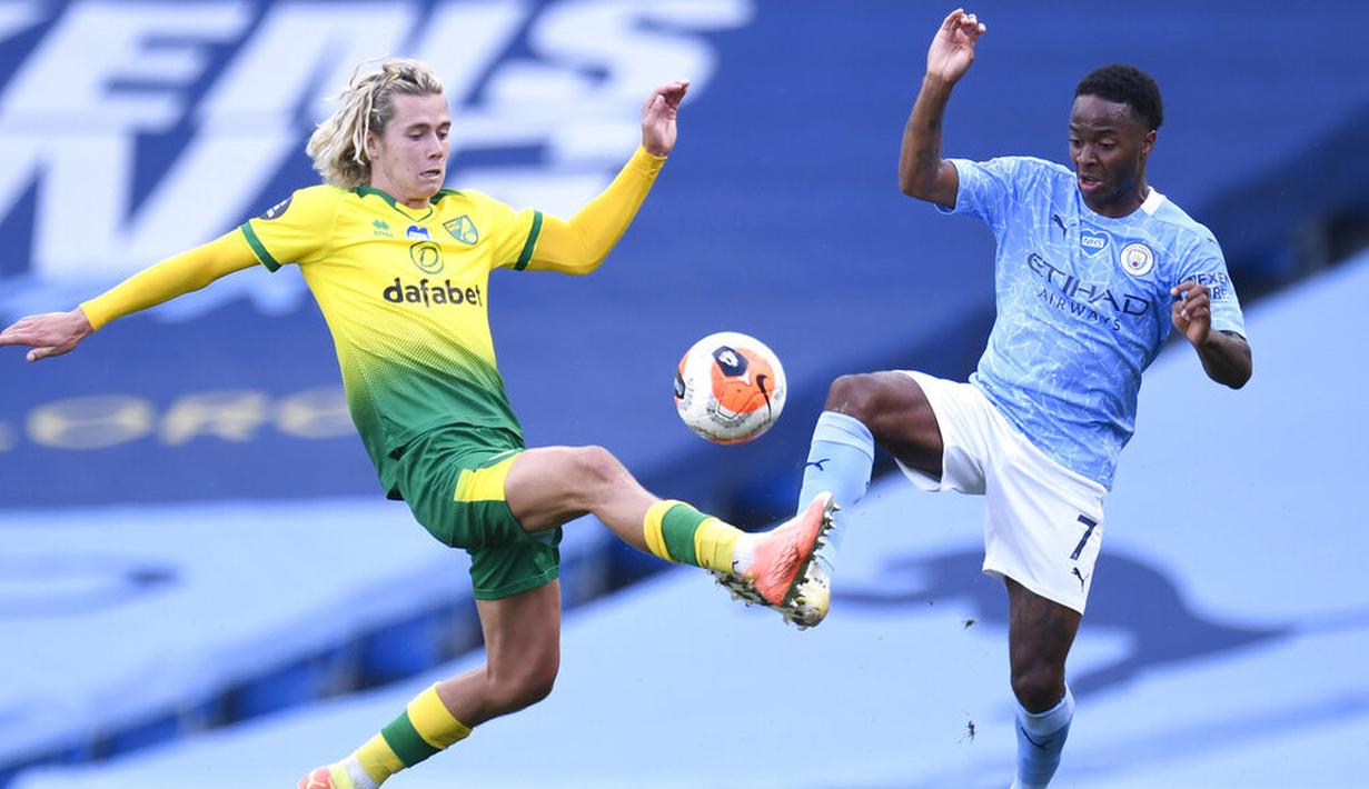 Pemain Manchester City, Raheem Sterling, berebut bola dengan pemain Norwich City, Todd Cantwell, pada laga Premier League di Stadion Etihad, Minggu (26/7/2020). Manchester City menang dengan skor 5-0. (AP Photo/Dave Thompson, Pool)
