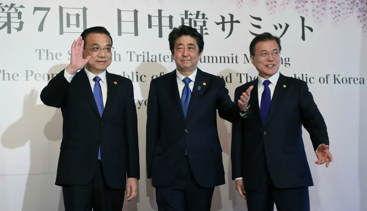 Perdana Menteri China Li Keqiang, Perdana Menteri Jepang Shinzo Abe dan Presiden Korea Selatan Moon Jae-in menyapa awak media usai melakukan pertemuan tingga negara di Tokyo, Jepang (9/5). (AP Photo/Eugene Hoshiko, Pool)