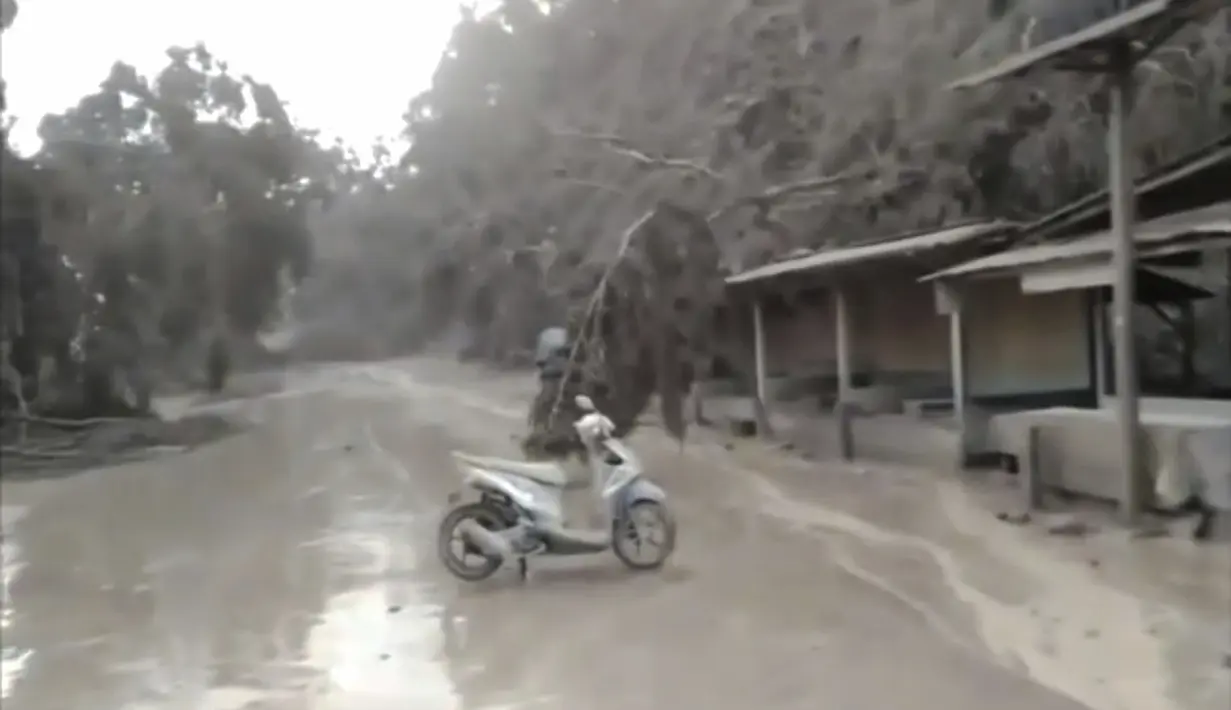 Abu menutupi jalan di Kabupaten Lumajang setelah letusan Gunung Semeru di Lumajang, Jawa Timur, Indonesia, Minggu (4/12/2021). Wakil Bupati Lumajang Indah Masdar melaporkan ada satu orang yang meninggal dunia akibat erupsi Gunung Semeru. (AP Photo)