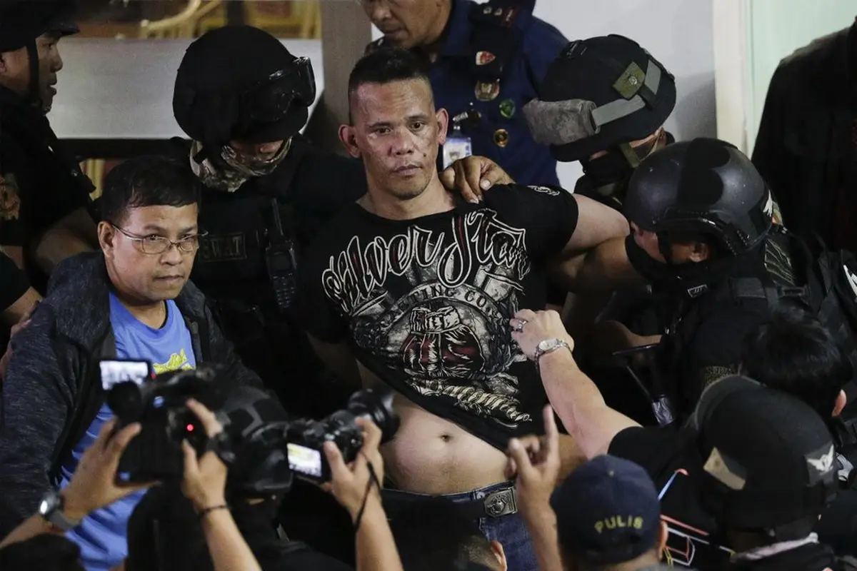 Polisi menahan penyandera Alchie Paray saat ia berbicara kepada media tak lama setelah melepaskan semua sandera di V-Mall di Manila, Filipina pada hari Senin, 2 Maret 2020.
