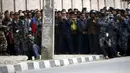 Warga dijaga oleh petugas saat melihat proses pengamanan benda mencurigakan dipinggir jalan kompleks kantor Singha Durbar, Nepal, (1/3). Daerah tersebut dekat dengan rumah kantor Perdana Menteri dan departemen lain. (REUTERS / Navesh Chitrakar)